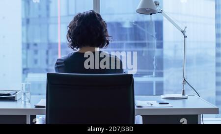 Belle femme d'affaires se tenant à son bureau au bureau avec vue sur la fenêtre CityScape. Femme réussie portant un vêtement habillé tenue de travail Banque D'Images