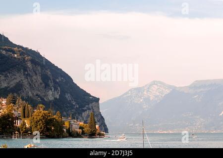 Lago di Garda (lac de Garde) au coucher du soleil avec du rose clair - une montagne en arrière-plan. Longue durée d'exposition - petites vagues Banque D'Images