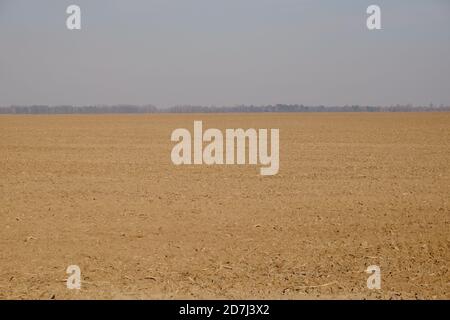 Ciel gris nuageux sur un champ agricole labouré. Terre argileuse. Paysage. Banque D'Images