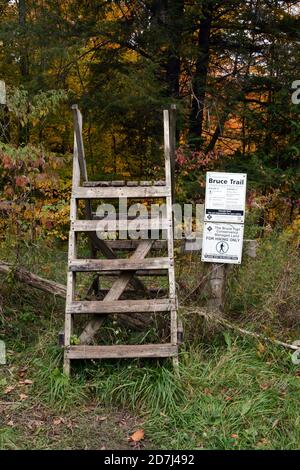 Une clôture et un panneau à un point de départ et d'accès au sentier de randonnée du sentier Bruce Trail en bordure du parc provincial Boyne Valley, Ontario, Canada. Banque D'Images