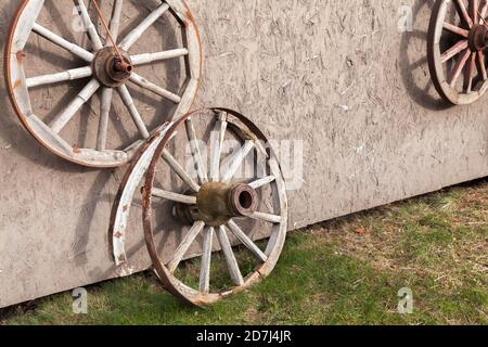 Les anciennes roues de chariot en bois sont près du mur rural Banque D'Images