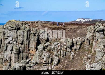 Fin de l'été, vue en haut de la falaise de Cornouailles près de Carn Boel avec des marcheurs sur le sentier côtier, détail de la falaise de Granite et le centre d'accueil de la fin des terres. Banque D'Images