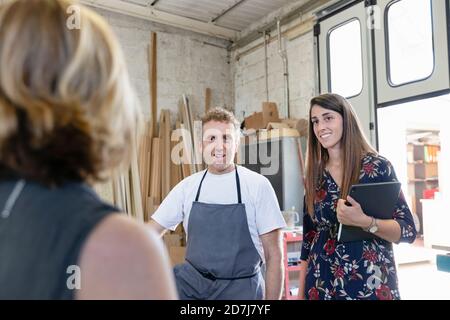 Un collègue et un chef de projet discutent avec l'employé tout en restant debout atelier Banque D'Images