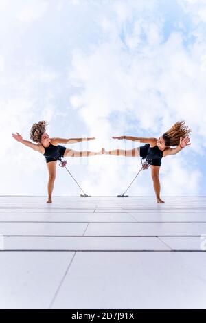 Des danseuses aux cheveux touffés dansent contre le ciel Banque D'Images