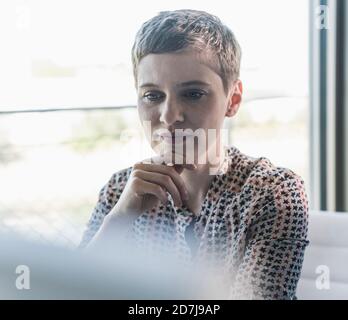 Gros plan d'une femme d'affaires avec des cheveux courts assis au bureau Banque D'Images