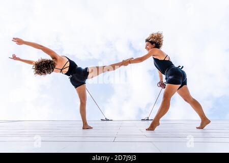 Danseurs aériens dansant sur la fenêtre contre le ciel Banque D'Images