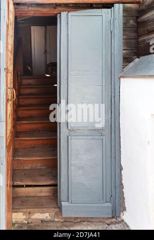 Vieille porte par un escalier avec des marches délabrées dans la maison rurale Banque D'Images