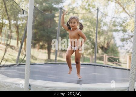 Fille debout en jouant à l'intérieur du trampoline Banque D'Images