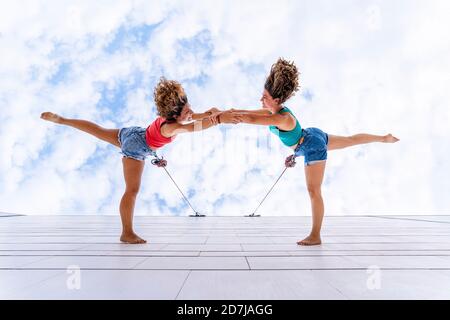 Danseuses aériennes avec des cheveux douchés dansant contre le ciel sur la fenêtre Banque D'Images