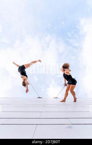 Danseurs aériens dansant contre le ciel Banque D'Images