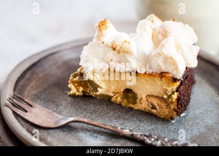 Tranche de cheesecake au rhubarbe avec meringues Banque D'Images