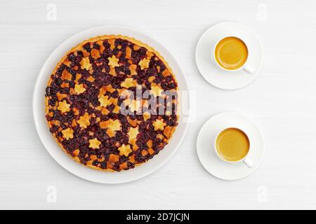 Tarte aux cerises maison à croûte courte et deux tasses d'espresso. Sur une table en bois blanc vue sur le dessus. Banque D'Images