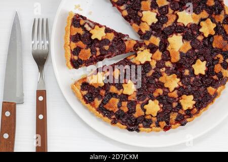 Gros plan sur une petite tarte aux cerises maison sur une table en bois blanc. Vue de dessus. Banque D'Images