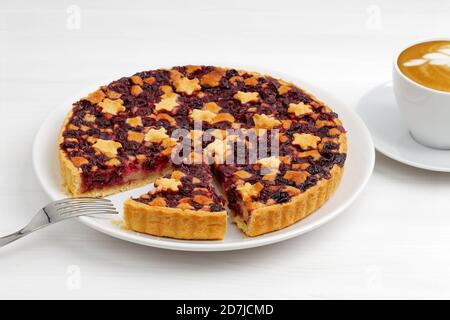 Tarte aux cerises maison à la croûte courte et tasse de café cappuccino sur une table en bois blanc. Banque D'Images