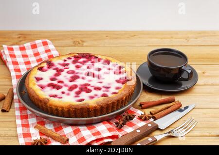 Tarte à la framboise maison avec garniture au yaourt et une tasse de thé sur une table en bois. Vue en angle. Banque D'Images