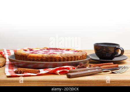 Tarte à la framboise maison avec garniture au yaourt et une tasse de thé sur une table en bois. Vue avant. CopySpace. Banque D'Images
