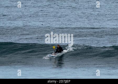 Saint-Jean-de-Luz, P-A / France - 22 octobre 2020 : un homme d'âge moyen surfant sur un vague dans l'océan Atlantique Banque D'Images