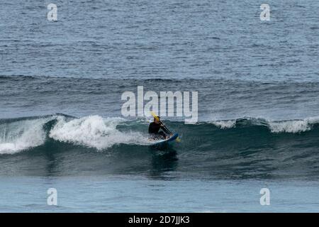 Saint-Jean-de-Luz, P-A / France - 22 octobre 2020 : un homme d'âge moyen surfant sur un vague dans l'océan Atlantique Banque D'Images