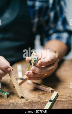 Luthier tenant le bâton de bois pendant le travail à l'atelier Banque D'Images