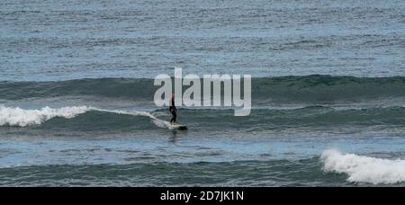 Saint-Jean-de-Luz, P-A / France - 22 octobre 2020 : un surfeur à cheval sur des vagues dans l'océan Atlantique à bord d'une longboard Banque D'Images