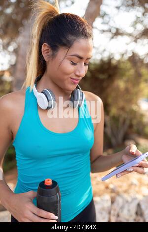 Femme hispanique souriante utilisant un smartphone Banque D'Images