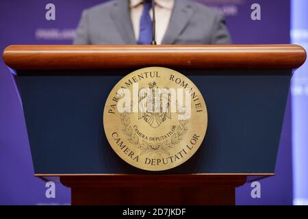 Bucarest, Roumanie - 23 octobre 2020 : logo de la Chambre des députés roumaine (la chambre basse du Parlement roumain) sur un bureau pendant qu'un député tient Banque D'Images