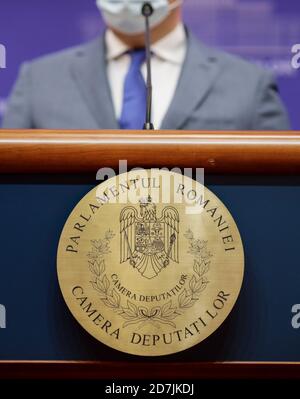 Bucarest, Roumanie - 23 octobre 2020 : logo de la Chambre des députés roumaine (la chambre basse du Parlement roumain) sur un bureau pendant qu'un député tient Banque D'Images