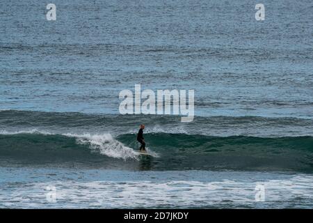 Saint-Jean-de-Luz, P-A / France - 22 octobre 2020 : un surfeur à cheval sur des vagues dans l'océan Atlantique à bord d'une longboard Banque D'Images