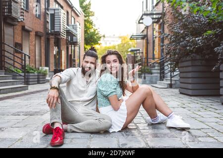 Heureux couple assis dans la rue dans la ville Banque D'Images