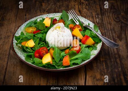 Assiette de salade végétarienne fraîche avec tomates, basilic, arugula, nectarines, baume de citron et fromage burrata Banque D'Images