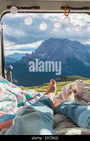 Homme se détendant dans le campervan contre la chaîne de montagnes, Sesto Dolomites, Dolomites, Alto Adige, Italie Banque D'Images