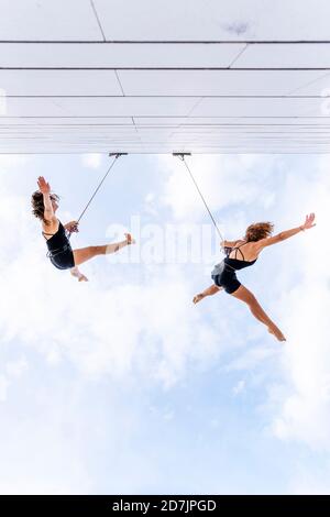 Danseurs dansant sur la fenêtre contre le ciel Banque D'Images