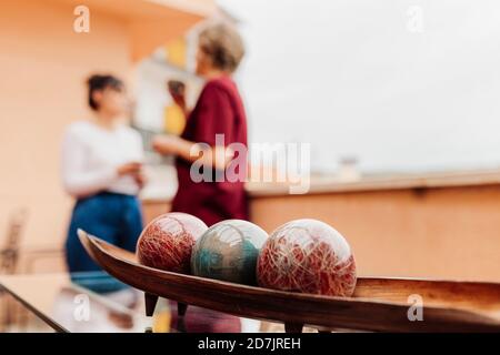 Ballon maintenu sur la table avec les femmes debout en arrière-plan Banque D'Images