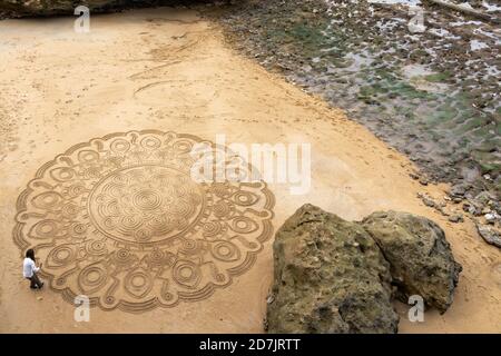 Biarritz, P-A / France - 21 octobre 2020 : un artiste de rue talentueux dessine le mandala dans le sable de la plage de Biarritz Banque D'Images