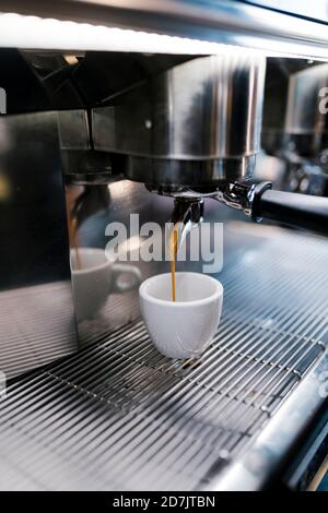 Le café est versé dans une tasse à travers les machines du café Banque D'Images