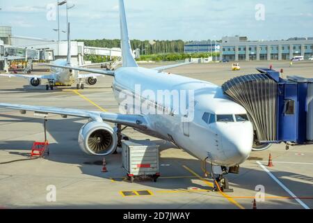 L'avion est relié au terminal gangway du bâtiment de l'aéroport pendant le ravitaillement avant le vol Banque D'Images