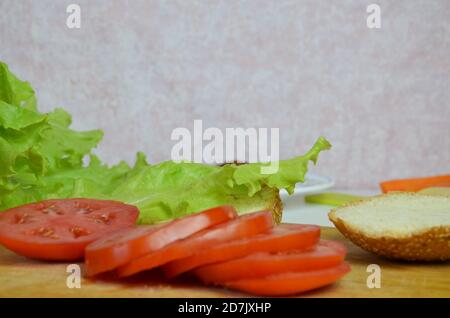 Hamburger fait maison avec du bœuf, de l'oignon, de la tomate, de la laitue et du fromage. Hamburger frais sur table rustique en bois Banque D'Images