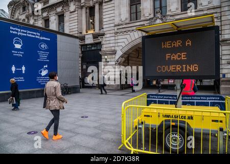 Londres, Royaume-Uni. 23 octobre 2020. À la gare Victoria, il y a des instructions pour porter des couvre-visage et d'autres conjances sur un grand panneau d'affichage - les transports publics à Londres sont plus occupés maintenant, tout comme le gouvernement commence à augmenter les contrôles de covid, face à des cas de hausse. Il y a des signes avertissant les gens de porter des masques, de se laver les mains et de maintenir la distance sociale. Crédit : Guy Bell/Alay Live News Banque D'Images