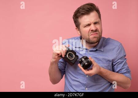 Voyageur et photographe. Studio portrait de beau jeune homme tenant photocamera prise de photo. Noir jaune. Banque D'Images
