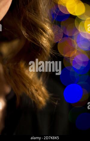 Effet bokeh avec des lumières de noël sur une fille aux cheveux blonds Banque D'Images