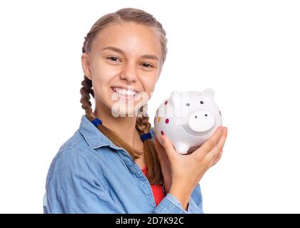 Belle adolescente tient une banque de porc dans ses mains, isolée sur fond blanc Banque D'Images