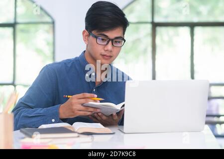 Jeune étudiant en utilisant le collage et l'appareil mobile de l'ordinateur étudiant en ligne. L'éducation et l'apprentissage en ligne. Banque D'Images