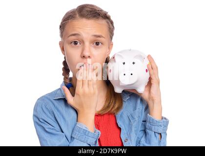 Belle adolescente tient une banque de porc dans ses mains, isolée sur fond blanc Banque D'Images