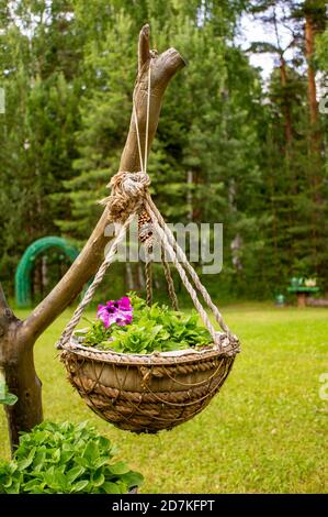 Pot de fleurs fait à la main accroché à un museau sur la pelouse dans le jardin. Herbe verte Banque D'Images