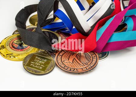 De nombreuses médailles de sport brillantes sur différents rubans colorés isolés sur fond blanc. Vue horizontale plate. Banque D'Images