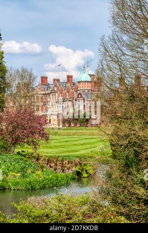 Sandringham House vue de l'autre côté des jardins ornementaux et d'une partie du lac dans le domaine. Banque D'Images