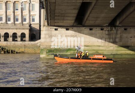 Le bateau de sauvetage RNLI passant sous le London Bridge, sur la Tamise, au Royaume-Uni Banque D'Images