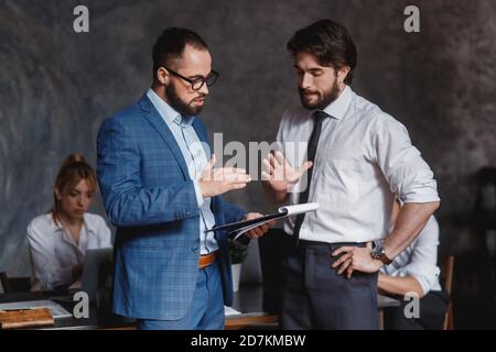 des collègues du caucase contestant le fait de ne pas avoir de désaccord au travail se blâmant mutuellement par erreur, divers collègues arguant sur le projet, ayant un conflit Banque D'Images