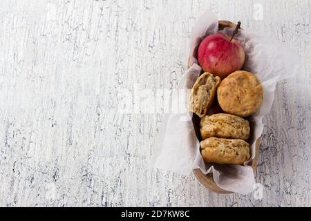 Pommes scones dans un bol en bois sur une surface blanche vintage, vue de dessus Banque D'Images