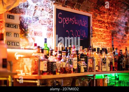 Warendorf, Allemagne. 23 octobre 2020. Au-dessus du bar n°1 à Warendorf, à côté de nombreuses bouteilles de boissons alcoolisées, il y a un tableau de surveillance avec l'inscription: 'Sperrstunde 23:00 Uhr'. En Rhénanie-du-Nord-Westphalie, un couvre-feu obligatoire entre 23:00 et 6:00 a été introduit pour le commerce de la restauration dans toutes les municipalités avec un grand nombre de nouvelles infections de corona. Le couvre-feu s'applique dans les municipalités de 50 nouvelles infections ou plus pour 100,000 habitants dans un délai de sept jours. Credit: Guido Kirchner/dpa/Alay Live News Banque D'Images